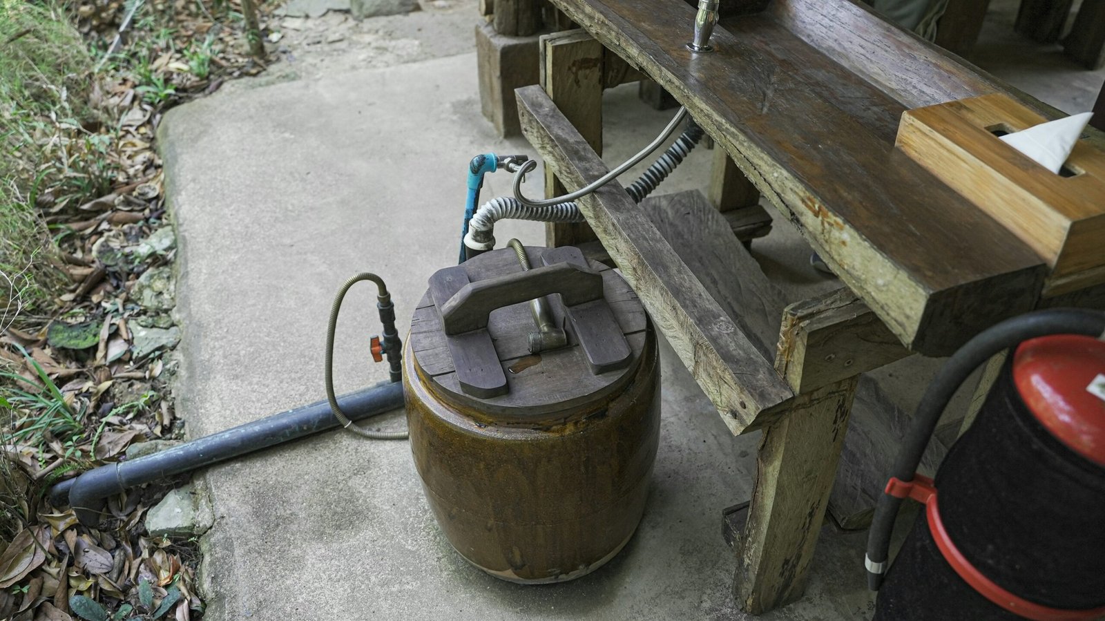 Cleaning wooden furniture surface with vinegar solution that is stored in a cylindrical wood tank.