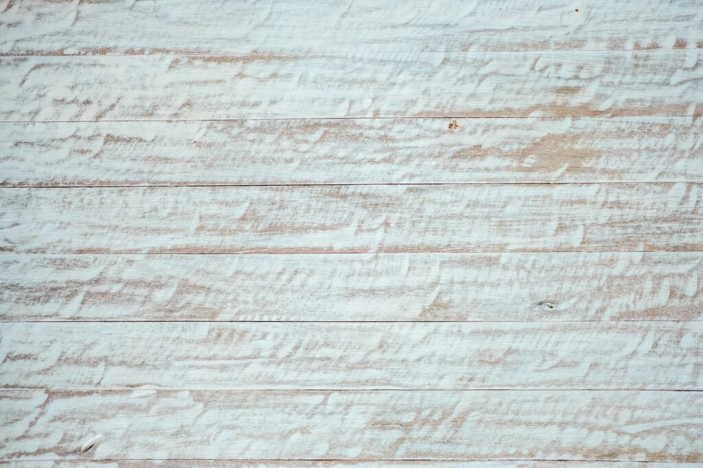 Distressed wood surface with white paint finish.