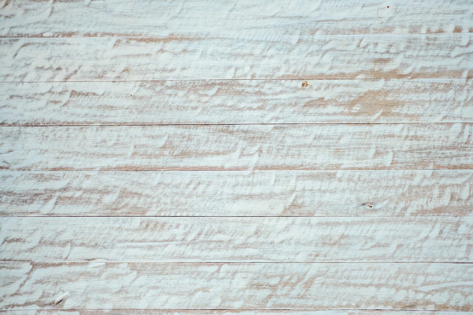 Distressed wood surface with white paint finish.